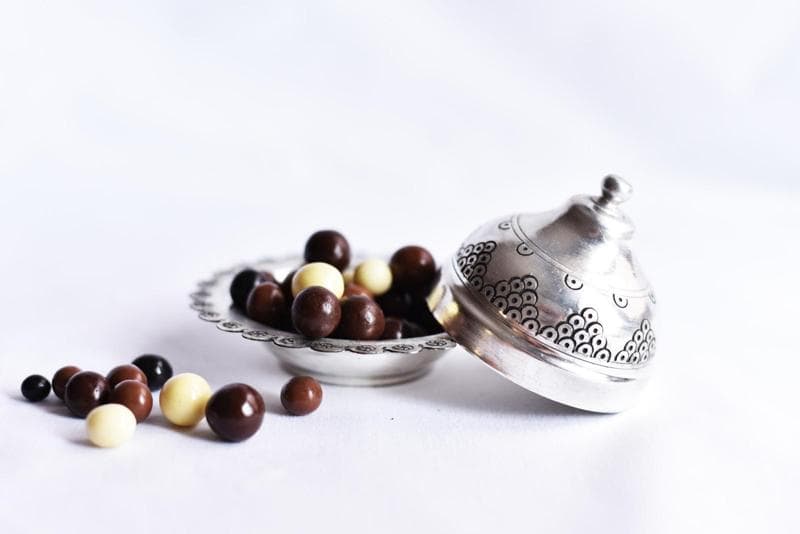 Chocolate covered coffee beans in silver bowl