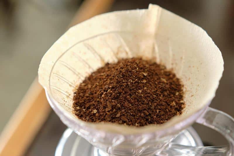 Freshly ground coffee beans in a wooden grinder for a perfect brew