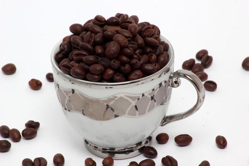 Fresh roasted peaberry coffee beans in a cup