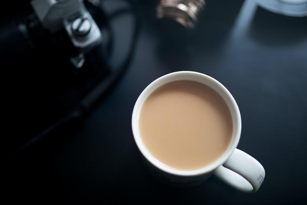 A steaming cup of smooth coffee brewing in a white mug