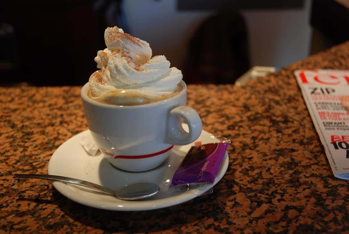 Enjoying a creamy coffee treat with a generous swirl of whipped cream